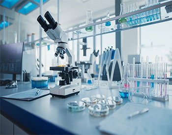 Modern Medical Research Laboratory with Microscope and Test Tubes with Biochemicals on the Desk.